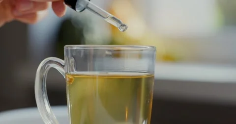 Dietary supplements and vitamins - adding drops in cup of tea with dropper Stock Footage 140971487