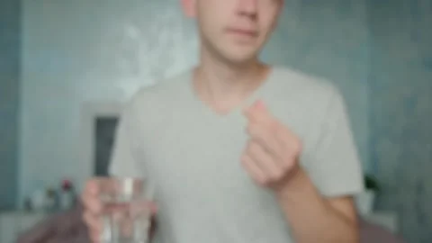 Dietary supplements. Man drinking omega 3 capsule with glass of water. Morning Stock-Footage 252040751