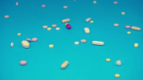 Dietary supplements pills falling on blue background slow motion video tablets Video stock 150963729