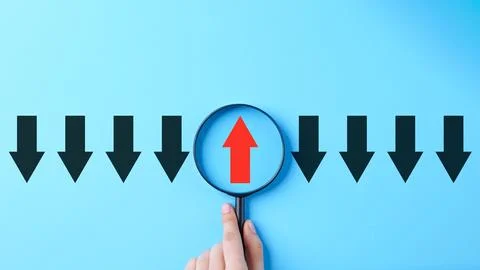 Difference concept. A single red upward arrow is view through magnifying gl.. Stock Photos