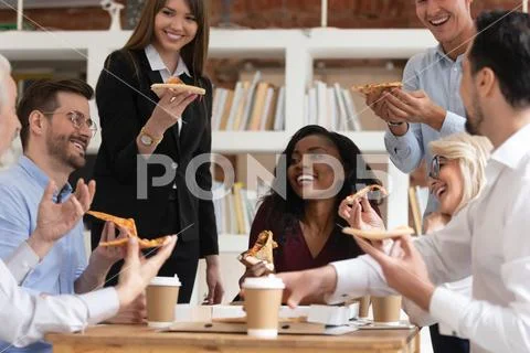 Different age ethnicity colleagues eat pizza during lunch at workday Stock Photos