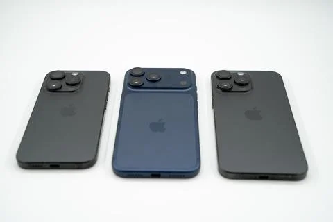 Different Apple iPhone models displayed side by side on white background. Stock Photos