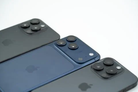 Different Apple iPhone models displayed side by side on white background. Stock Photos