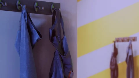 Different aprons hanging on hooks in a locker room area Stock Footage 340610347