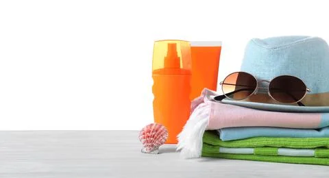 Different beach objects on wooden table against white background Stock Photos