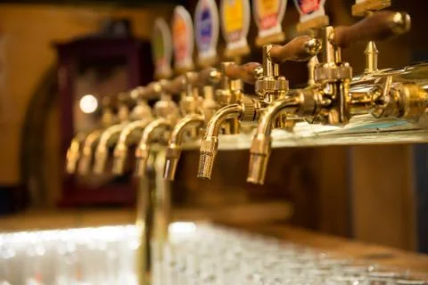 Different beer taps in a row. Stock Photos