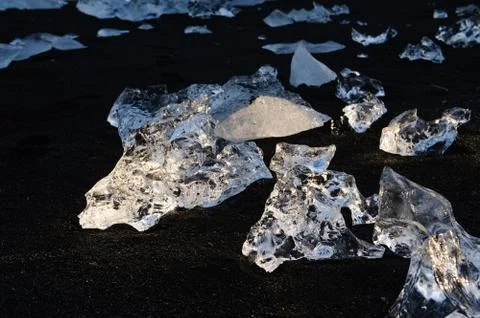 Different blocks of ice in the sun on black sand, Iceland Stock Photos