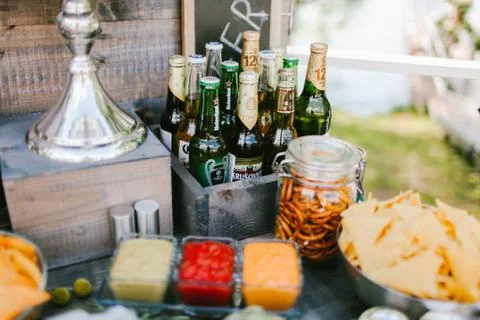 Different brands of beer bottles with snacks Stock Photos