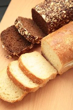 Different bread on plate on light background. Vertical photo Stock Photos