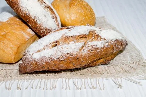 Different bread round baguette isolated on white wood background. Stock Photos