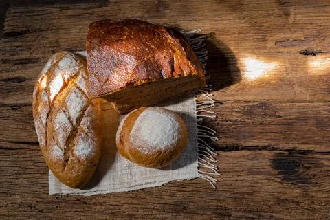 Different bread rye round baguette isolated on wood background. Stock Photos