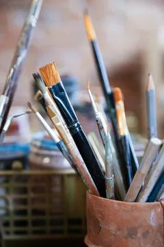 Different brushes in drawing studio interior. Close up view , vertical shot Stock Photos