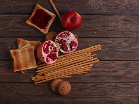 Different buns of fresh bread and spikelets of wheat on a brown vintage backg Stock Photos