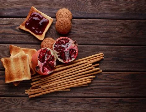 Different buns of fresh bread and spikelets of wheat on a brown vintage backg Stock Photos