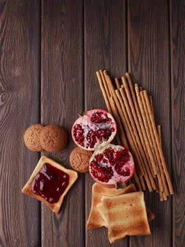 Different buns of fresh bread and spikelets of wheat on a brown vintage backg Stock Photos