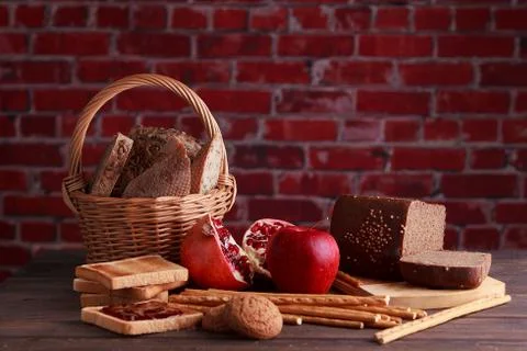 Different buns of fresh bread and spikelets of wheat on a brown vintage backg Stock Photos