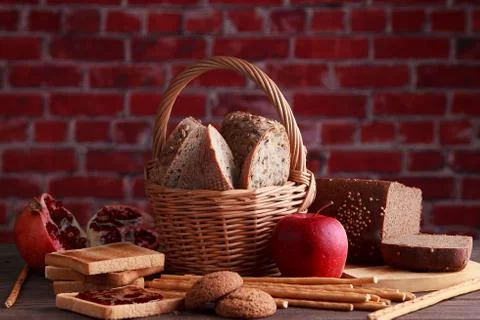 Different buns of fresh bread and spikelets of wheat on a brown vintage backg Stock Photos