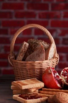 Different buns of fresh bread and spikelets of wheat on a brown vintage backg Stock Photos