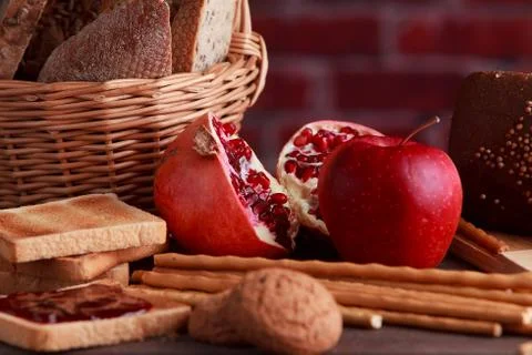 Different buns of fresh bread and spikelets of wheat on a brown vintage backg Stock Photos