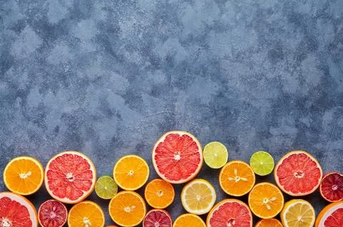 Different citrus fruit on dark grey concrete table. Fruit food background Stock Photos