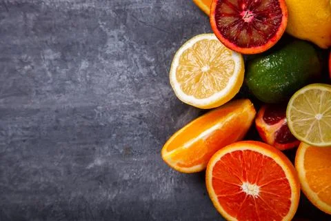 Different Citrus Fruit on a Grey Background .Mixed Colorful Tropical Backgrou Stock Photos