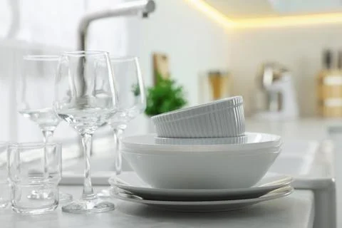 Different clean dishware and glasses on countertop in kitchen Stockfoto's