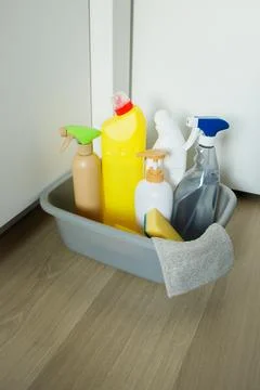 Different cleaning products and tools standing in basin on the floor at hom.. Stock Photos