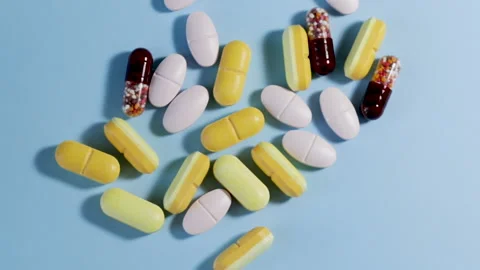 Different color pills on blue background. Natural herbs Stock-Footage 165676779