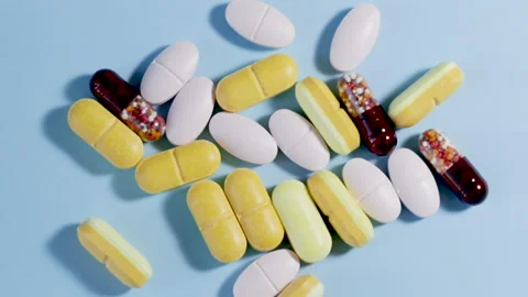 Different color pills on blue background. Natural herbs Stock Footage 165677439