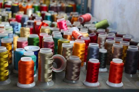 Different color spools of thread for the textile industry. background Stock Photos