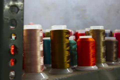 Different color spools of thread for the textile industry. background Stock Photos