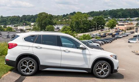 Different colored BMW SUVs lined up downhill at a dealership Foto stock
