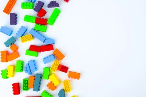 Different colored building blocks scattered across a white isolated backgroun Stock Photos