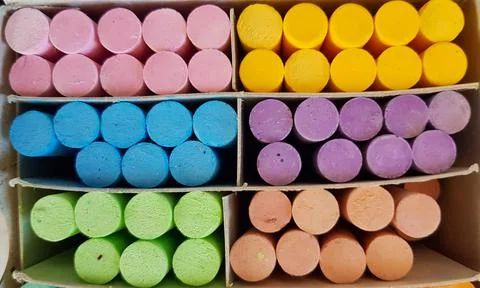 Different colored chalks are neatly arranged in a box. Foto stock
