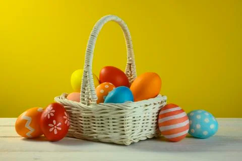 Different colored easter eggs lie in a basket Stock Photos