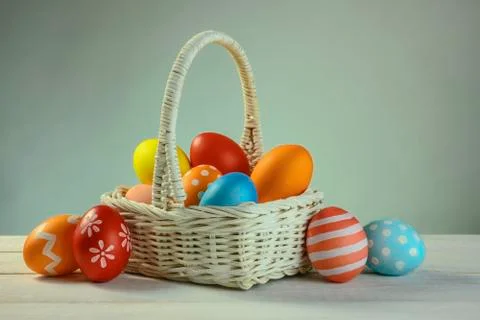 Different colored easter eggs lie in a basket Stock Photos