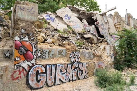 Different colored graffiti on the walls of the destroyed building. Stock Photos