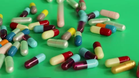 Different colored pills on a green screen Stock Footage 252485049