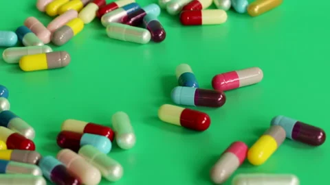 Different colored pills on a green screen Stock Footage 252485059