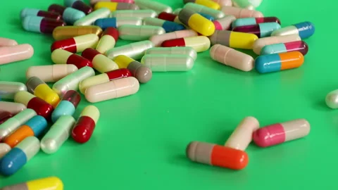 Different colored pills on a green screen Stock Footage 252485081