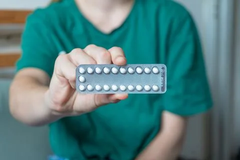 Different colored pills in a hand. Shaking Pills out of a pill bottle. Stock Photos