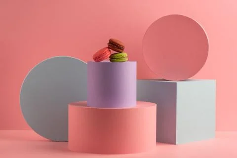 Different colorful macarons on round boxes on pink background Stock Photos
