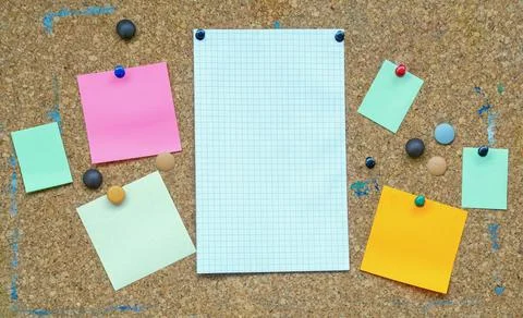 Different colorful notes on old cork board. Free space for text or images Stock Photos