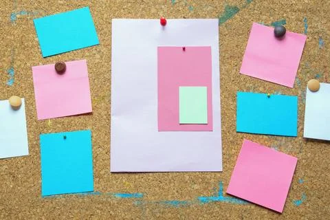 Different colorful notes on old cork board. Free space for text or images Stock Photos
