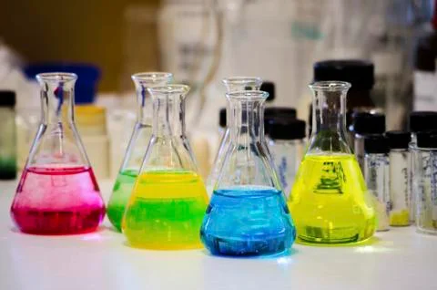 Different colorful solution in conical flask on a bench in a chemistry lab wi Stock Photos