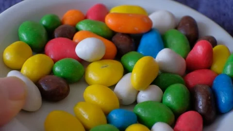 Different colors candy pebbles human hand man testing Stock Footage 303264059