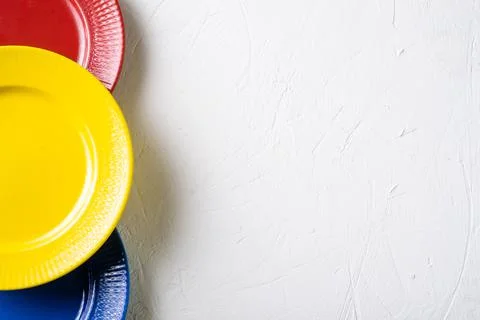 Different colors of empty plates. White background. Red, blue and yellow clay Stock Photos