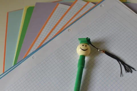 Different colors sheets with a pen in the shape of a student Foto stock