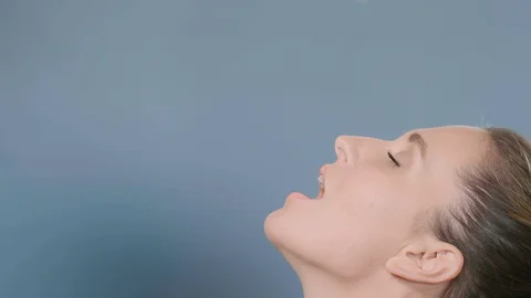 Different coloured pills fall on young woman face and mouth 스톡 동영상 127976262