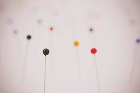 Different coloured pins on a light background Stock Photos